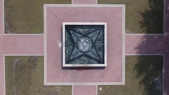 This clip is a vertical pull away, birds eye view, shot of a fountain in a park plaza. This shot was filmed on a Phantom 4 drone.