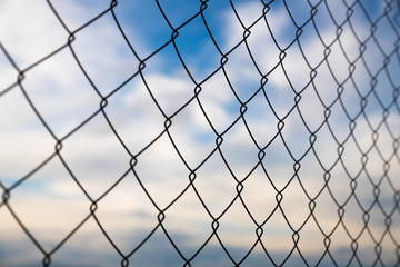 Close up of wire mesh fence (Rabitz) with cloudy sky at the background.