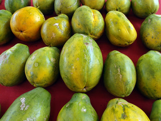 Rows of Hawaiian papayas on red cloth