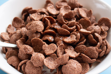 Bowl of cereal chocolate flavor and milk breakfast with silver spoon