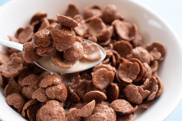 Bowl of cereal chocolate flavor and milk breakfast with silver spoon