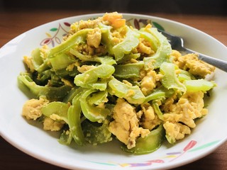 Stir-fried egg with bitter melon on a white dish