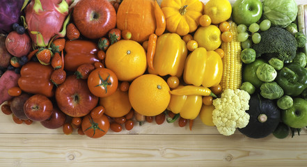 Colorful fresh fruits and vegetables on wood background, healthy eating concept.