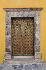 Obraz premium Artistically carved wooden door, Colonial style house in san Miguel de Allende Mexico