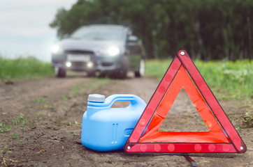 Fuel finished concept. Not enough gasoline. Red emergency triangle stop sign, empty canister for...