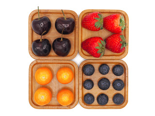 Fresh summer fruits, Cherry, strawberry, cape gooseberry and blueberry in wooden plate isolated on white background.