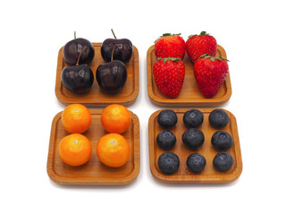 Fresh summer fruits, Cherry, strawberry, cape gooseberry and blueberry in wooden plate isolated on white background.