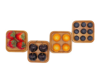 Fresh summer fruits, Cherry, strawberry, cape gooseberry and blueberry in wooden plate isolated on white background.