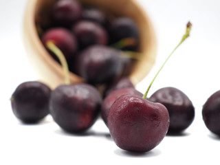 Fresh sweet cherry in shopping cart or trolly isolated on white background.