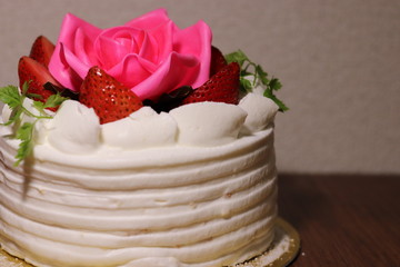 Obraz na płótnie Canvas 薔薇の花といちごが上に乗ったケーキ