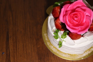 薔薇の花といちごが上に乗ったケーキ