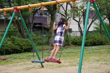公園のブランコで遊ぶ子供