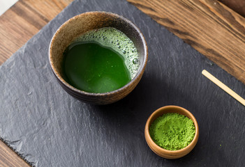 green matcha tea prepearing on stone black table 