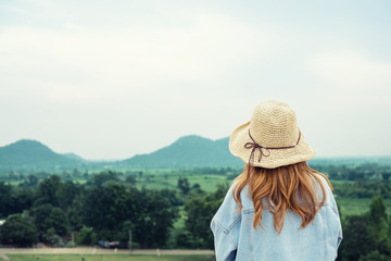 Young beautiful women hipster style wearing hat enjoy life looking mountain with blue sky.