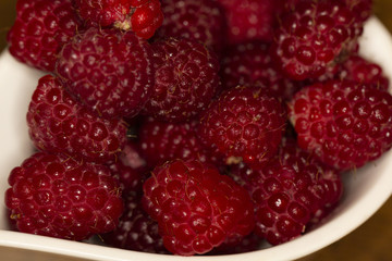 Pick raspberries in a bowl. Red raspberries. Raspberries are grown in a home garden. Fresh red raspberries.