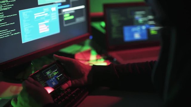 Professional hacker working with multiple devices