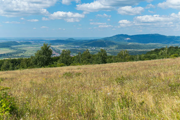an endless blue sky over a town lying between small mountains