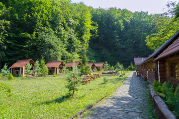 Fototapeta na wymiar a recreation area and a picnic area with gazebos and houses of a wooden beam in a green coniferous forest