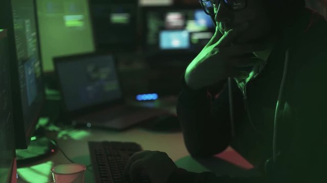 Black hat hacker working in his basement late at night