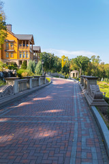 A wide alley lined with tiles on the approach to a chic wooden house