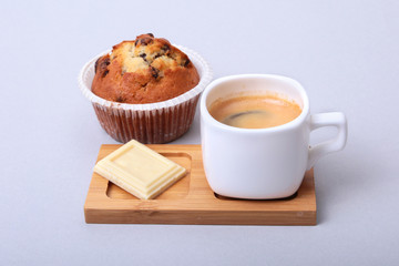 Classic espresso in white cup with homemade cake and chocolate on white background.