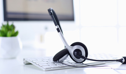Communication support, call center and customer service help desk. VOIP headset on laptop computer keyboard