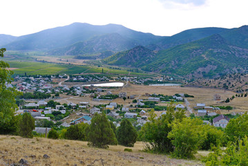 Fototapeta premium industrial unpopular small town in the valley of mountains with small ponds and green fields