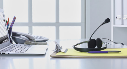 Communication support, call center and customer service help desk. VOIP headset on laptop computer keyboard