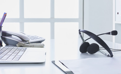 Communication support, call center and customer service help desk. VOIP headset on laptop computer keyboard