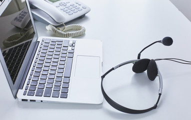 Communication support, call center and customer service help desk. VOIP headset on laptop computer keyboard