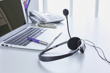 Communication support, call center and customer service help desk. VOIP headset on laptop computer keyboard
