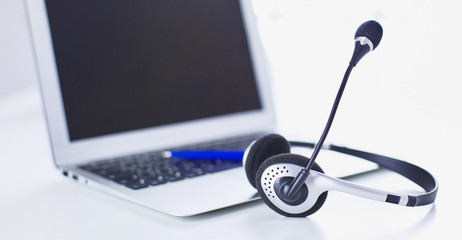 Communication support, call center and customer service help desk. VOIP headset on laptop computer keyboard