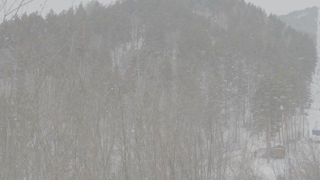Overview of snow mountains and cable chairlift. Beautiful winter forest at a resort in the mountains. S-log, ungraded