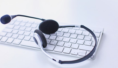 Communication support, call center and customer service help desk. VOIP headset on laptop computer keyboard