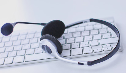 Communication support, call center and customer service help desk. VOIP headset on laptop computer keyboard