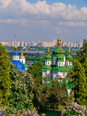 Fototapeta na wymiar Vydubitsky monastery in Kiev with flowering chestnuts in the foreground