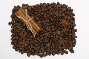 Background of coffee beans. Coffee texture. Cinnamon sticks and cardamom.