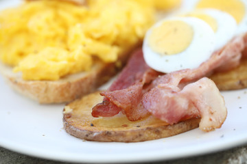 breakfast with scrambled eggs, fried potatoes bacon and shrimp