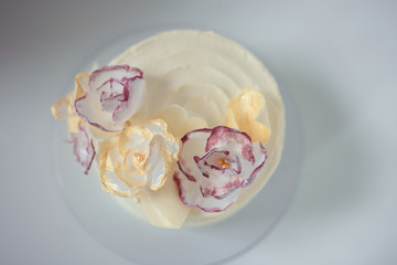 white cake on a white background with a wafer flowers