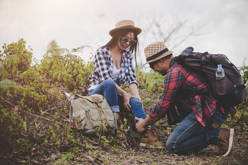 Asian young couple travelers to hiking  ankle injury on a green background, Hiking concept.