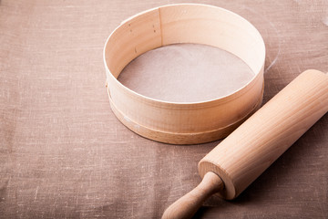 Baking ingredients. Flour, eggs, wheat and rolling pin on  table cloth. Rustic. Copy space