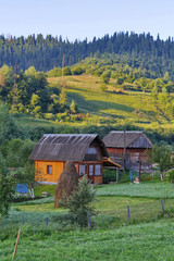 Small houses in a mountainous area with beautiful nature. With a farmer's farm near the houses and planted crops.