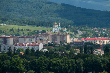 houses with red roofs and a church with golden domes in the Carpathians