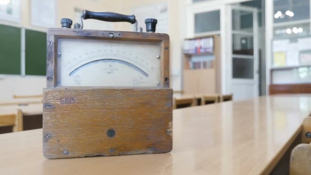 Old style voltmeter or ammeter with pointer showing different electric low voltage or current values. The ammeter in physical laboratory of School, College, University
