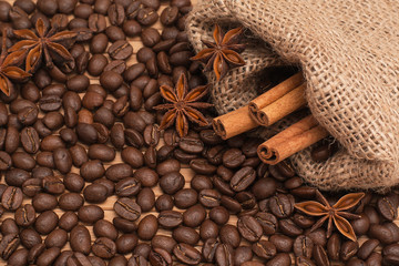 Background of coffee beans. Coffee texture. Cinnamon sticks and cardamom.