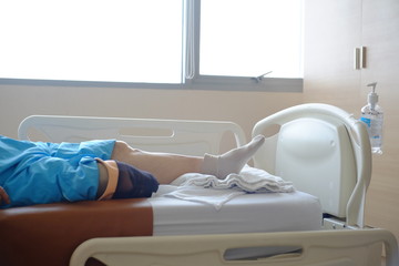 The older with prosthetic leg sleep on bed in hospital.