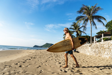 A man with a surfboard by the coast