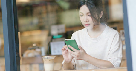 Woman use of mobile phone in cafe