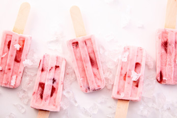 Red Fruit Yogurt Popsicles Chilling on Ice