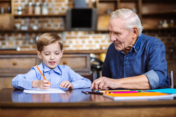 Little boy drawing with his grandfather